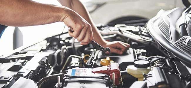 A service technician working on the engine of a vehicle