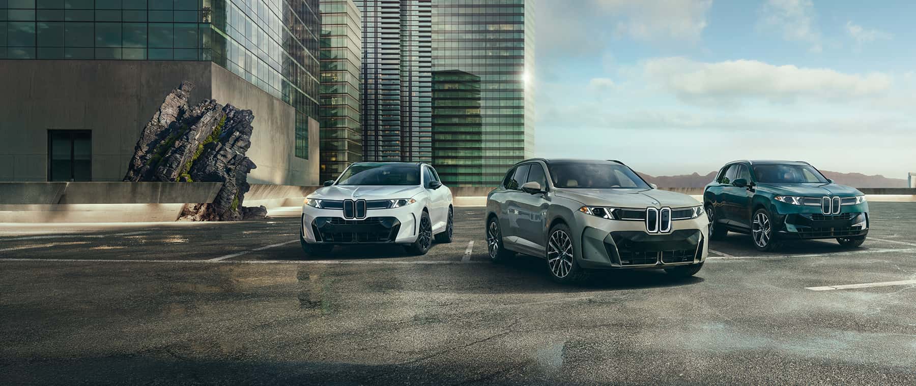 Image of 2027 BMW X5 family of ICE, BEV, PHEV in front of a cityscape.