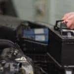 Mechanic removing car battery