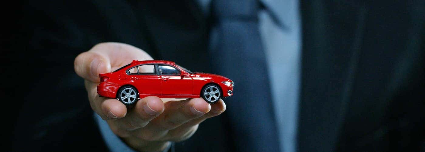 dealer holding mini car up