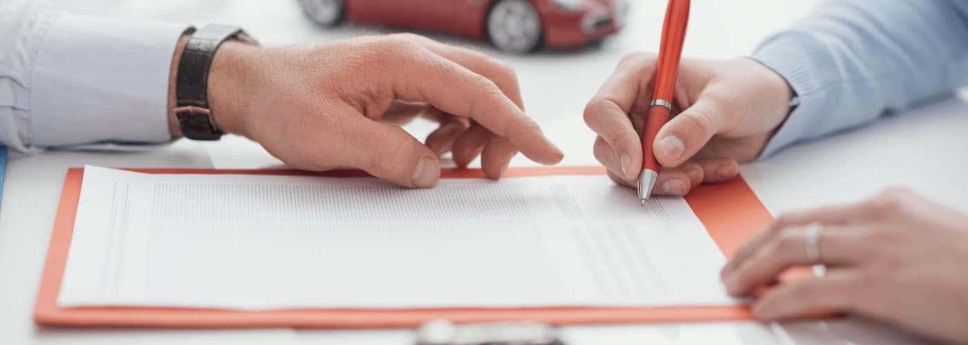 man helping woman sign document