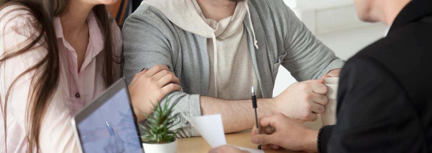 young couple signing loan agreement