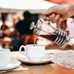 Coffee pouring into a cup from a french press