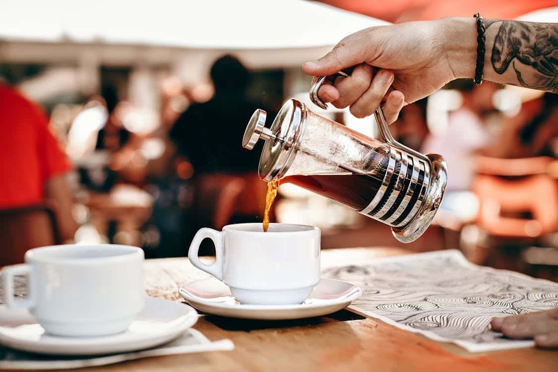 Coffee pouring into a cup from a french press
