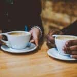 Two people enjoying cups of coffee at a coffee shop