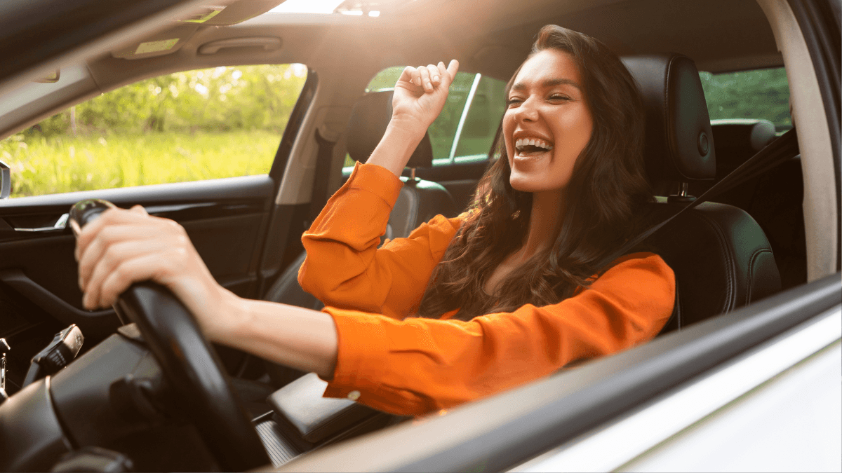 A joyful woman in the drivers seat of her Mercedes