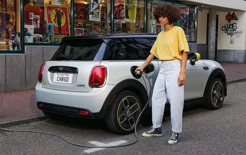 Explore The 2024 MINI Electric Hardtop 2 Door In Wesley Chapel FL   2024 Mini Electric Charging Woman 