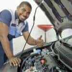 Mechanic looking under hood of car