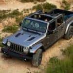 Silver 2020 Jeep Gladiator truck driving off road with the top off and windows down
