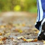 Woman walking cross country and trail in autumn forest