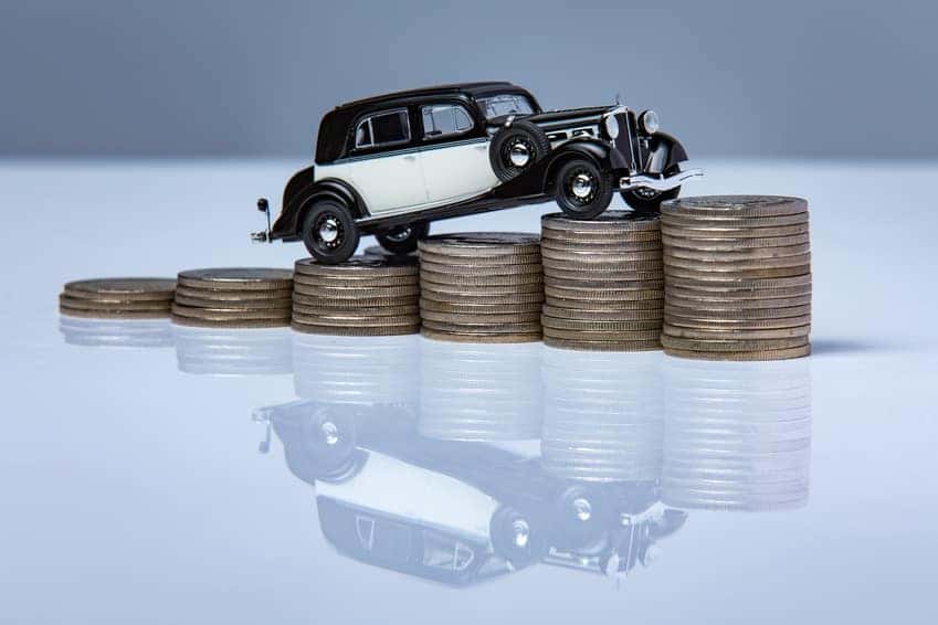 Car driving up stacks of coins, symbolizing the Honda finance process