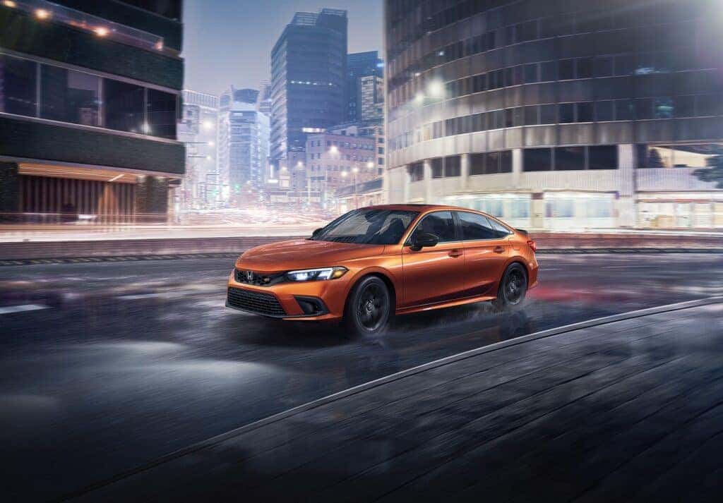 The 2023 Honda Civic Si driving in a cityscape