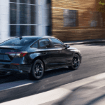 2025 Honda Civic driving in the city during the day