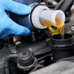 A mechanic performing an oil change on a new luxury vehicle.