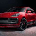 A red Porsche Macan on a gray surface.