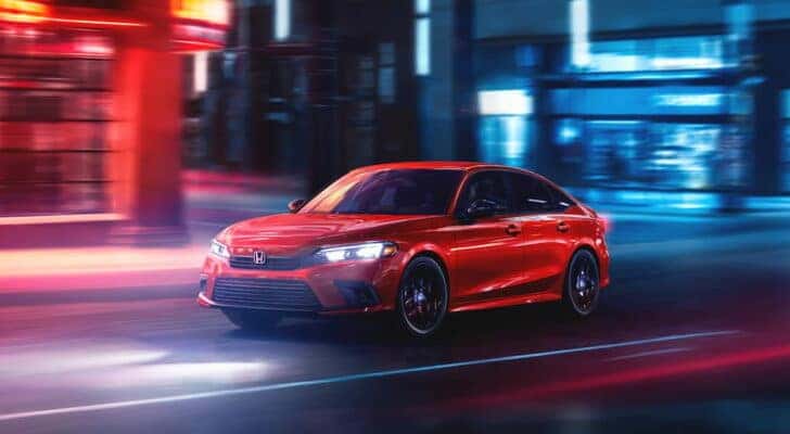 A red 2024 Honda Civic driving from a Honda dealer near Jefferson City.