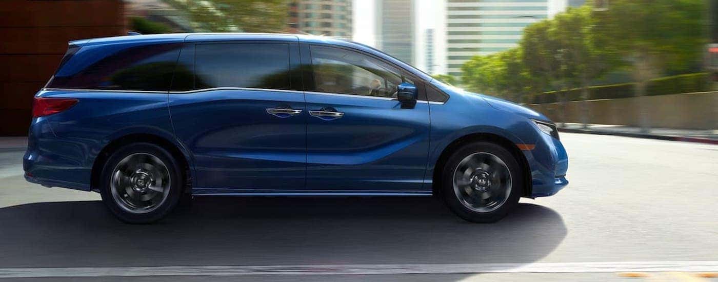 A blue 2024 Honda Odyssey for sale is shown from the side.