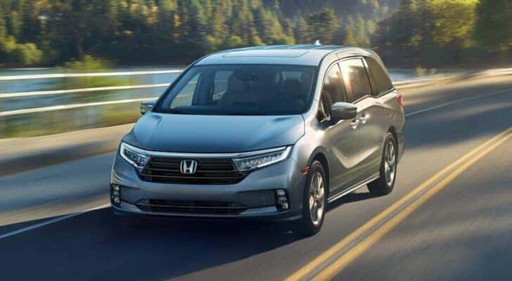 A grey 2024 Honda Odyssey is shown from the front at an angle.