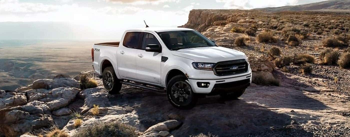 A white 2023 Ford Ranger FX4 is shown parked near a cliff after viewing used trucks for sale.