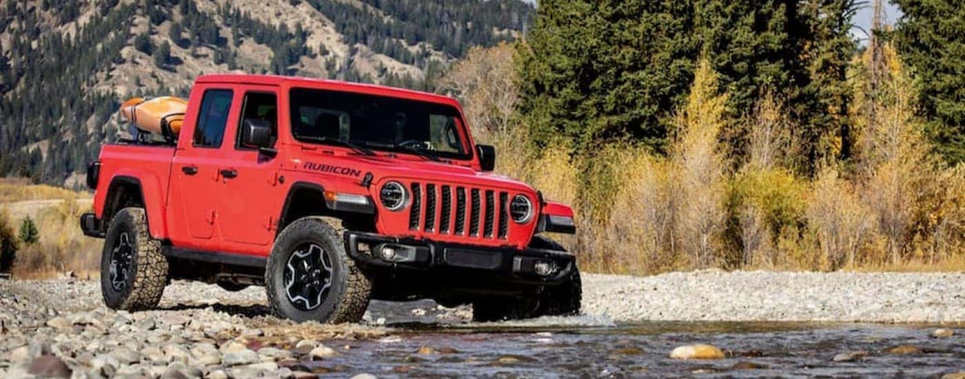 A red 2020 Jeep Gladiator is shown driving off-road.