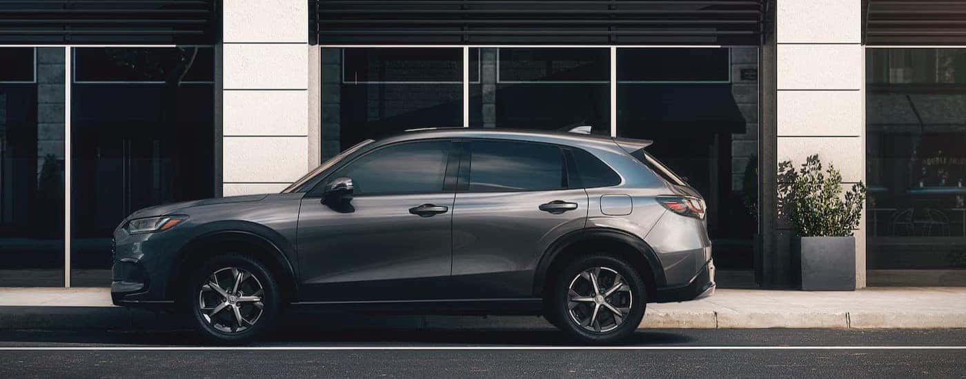 A 2025 Honda HR-V EX-L is shown parked near a city building.