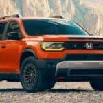 An orange 2026 Honda Passport TrailSport Elite is shown parked off-road after visiting a Honda dealer near Morristown.