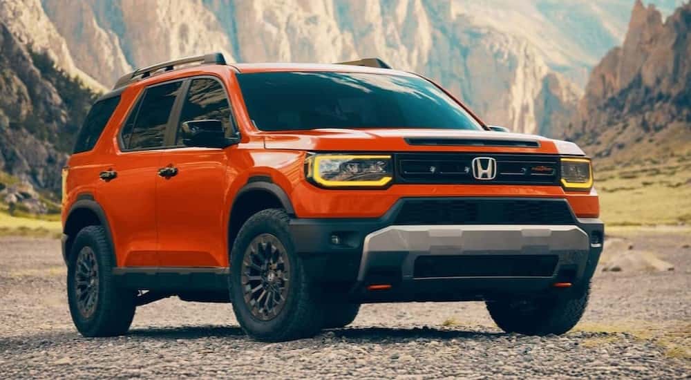 An orange 2026 Honda Passport TrailSport Elite is shown parked off-road after visiting a Honda dealer near Morristown.