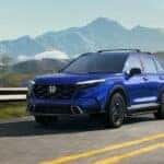 A blue 2025 Honda CR-V Hybrid for sale is shown from the front at an angle.