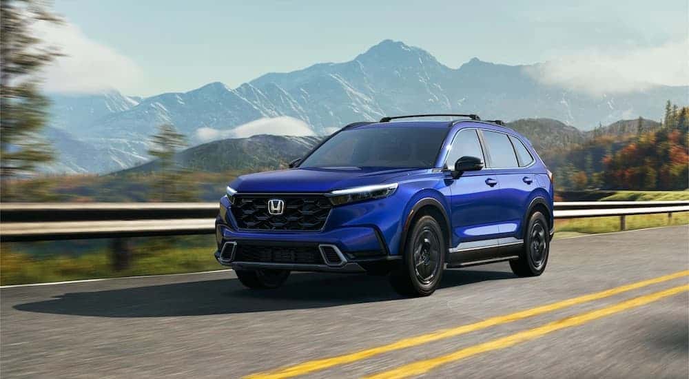 A blue 2025 Honda CR-V Hybrid for sale is shown from the front at an angle.