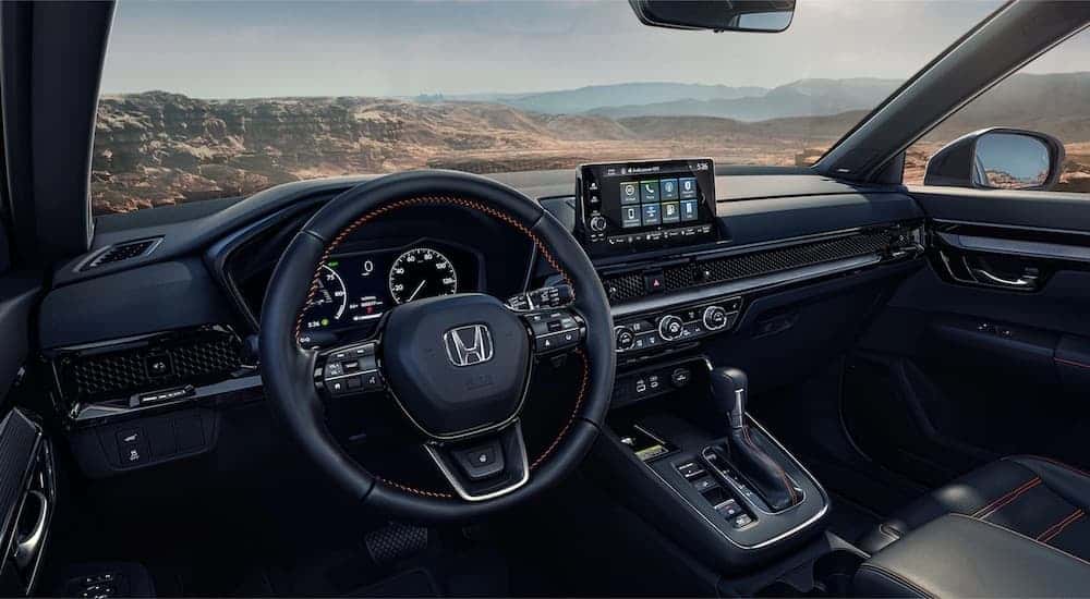 The black interior of a 2025 Honda CR-V is shown from the drivers seat.