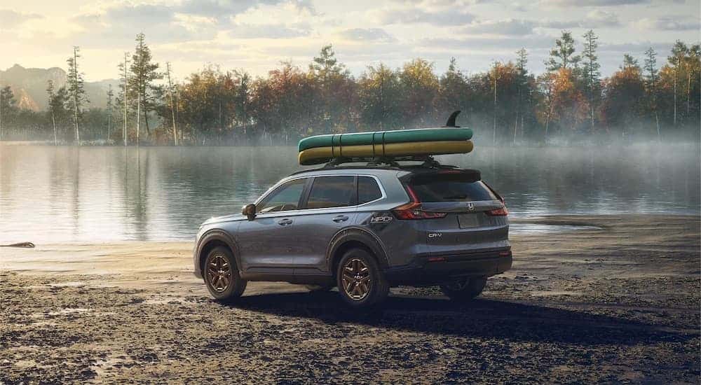 A grey 2025 Honda CR-V Hybrid is shown from the rear at an angle.