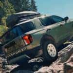 A green 2026 Honda Passport TrailSport Elite is shown off-roading.