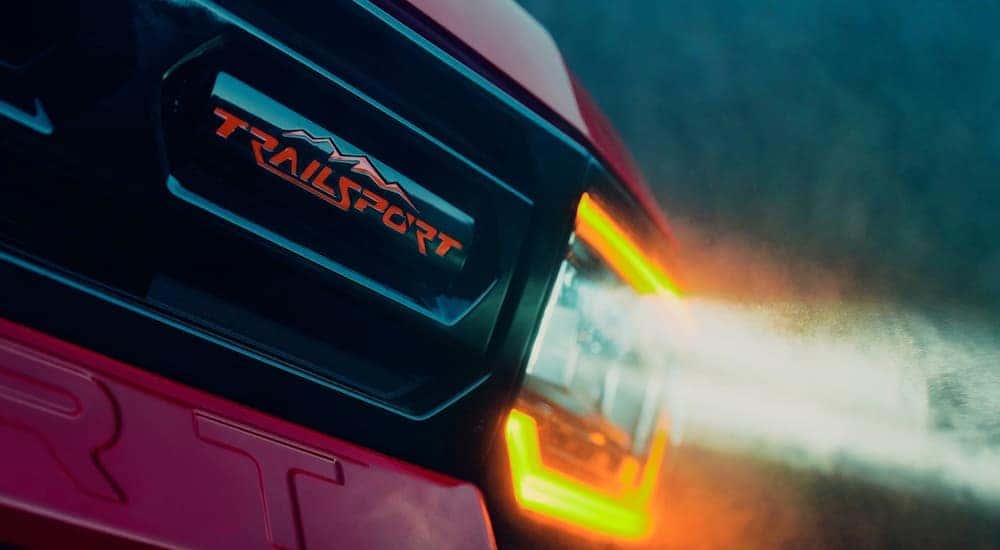 A close up of the headlight on a red 2025 Honda Passport Trailsport Elite for sale.