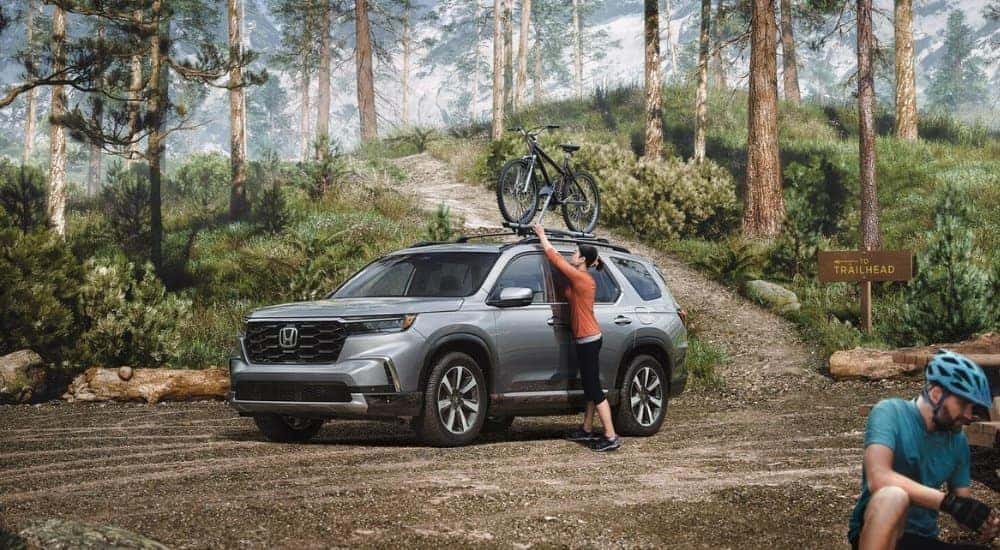 A grey 2025 Honda Pilot being unloaded at a trailhead.
