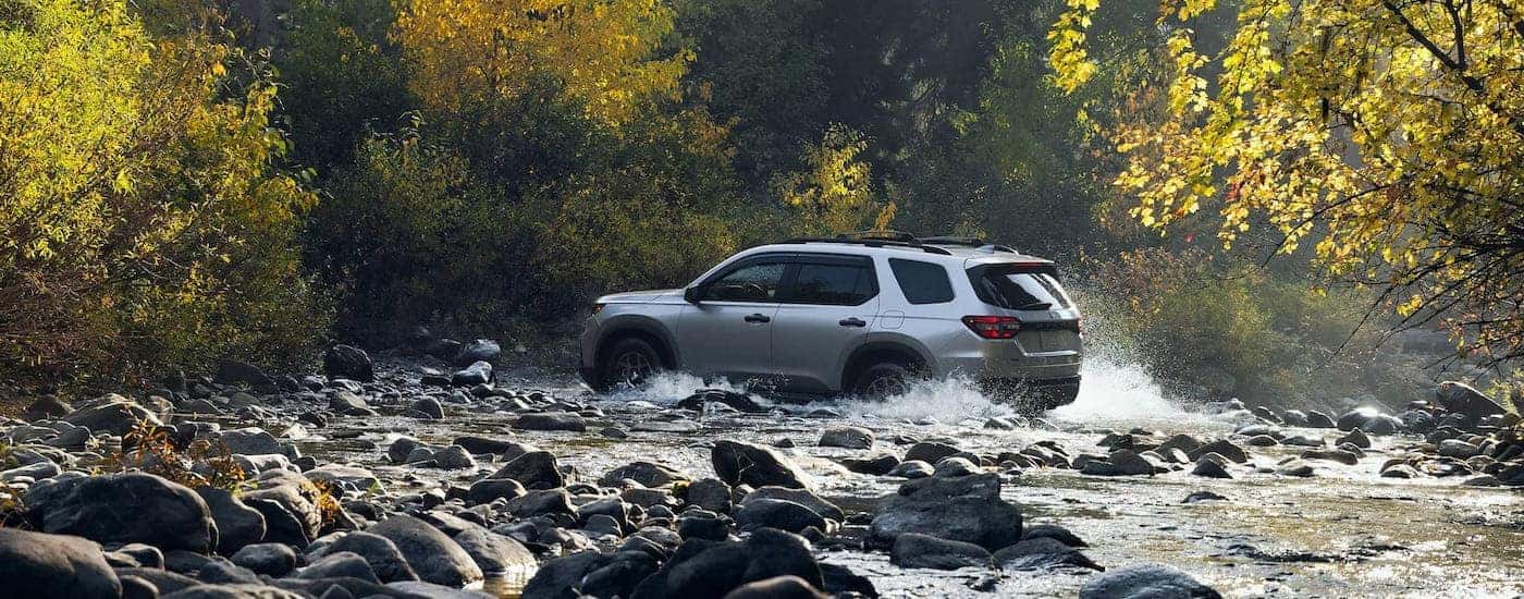 A grey 2025 Honda Pilot crossing a creek.