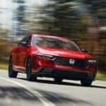 A red 2025 Honda Accord for sale driving down the road