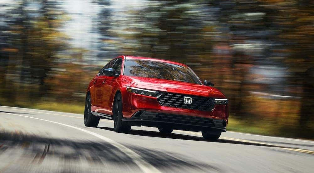 A red 2025 Honda Accord for sale driving down the road
