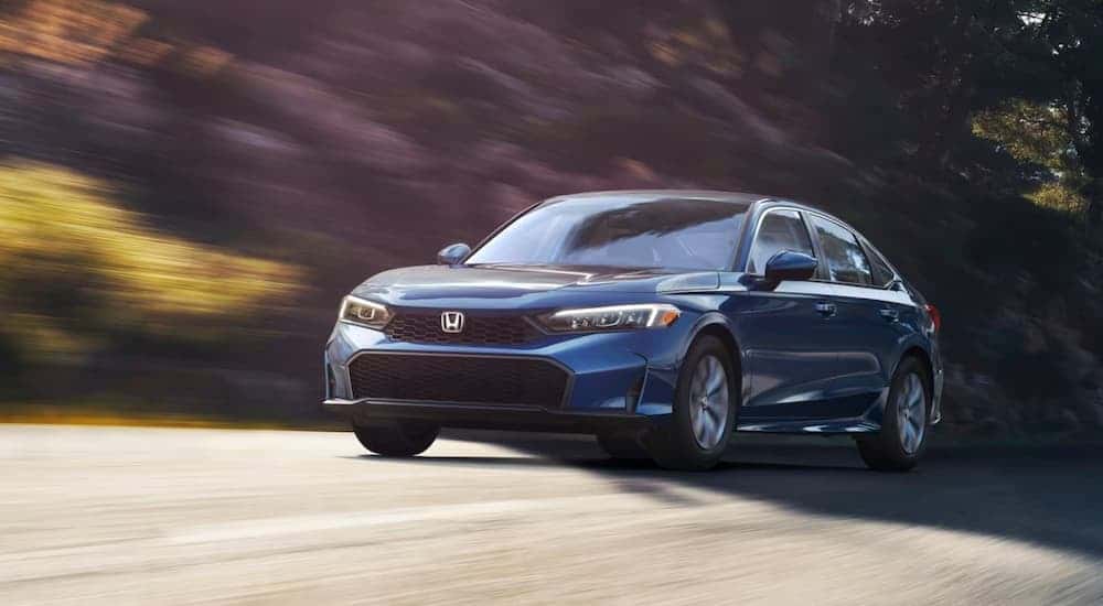 Blue 2025 Honda Civic Hybrid LX for sale in Knoxville driving on an open road