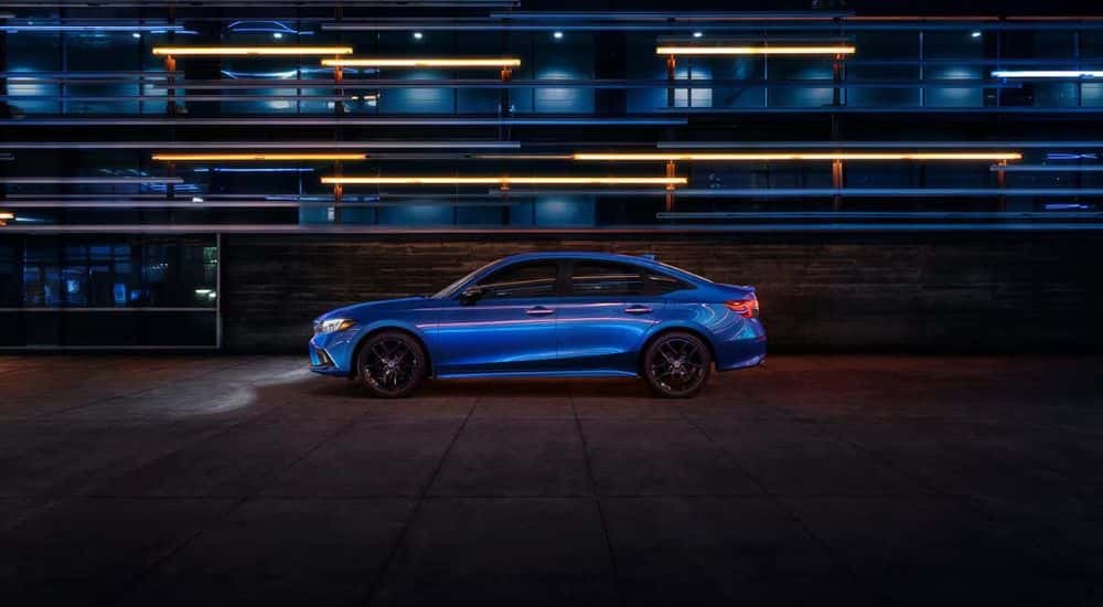 Blue 2022 Honda Civic with lights on while parked at night