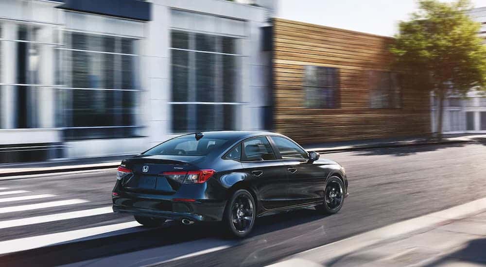 Black 2022 Honda Civic Sport driving down a street