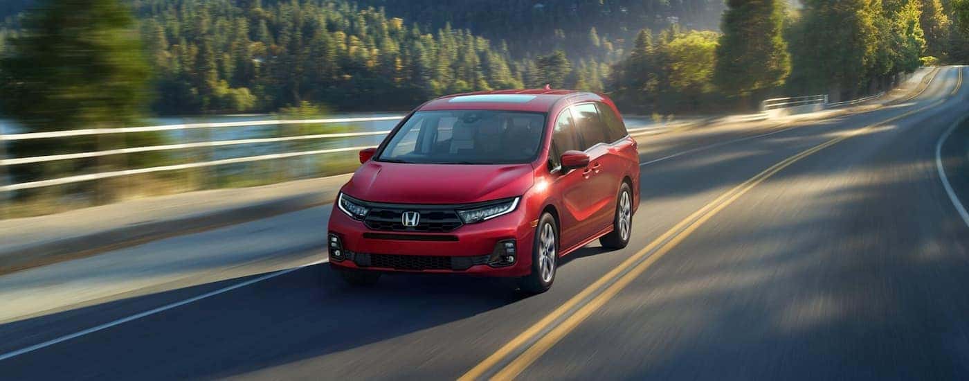 Red 2025 Honda Odyssey Elite driving on an open road