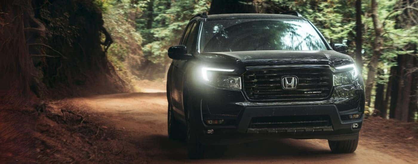 Black 2025 Honda Passport Black Edition driving on a dirt road