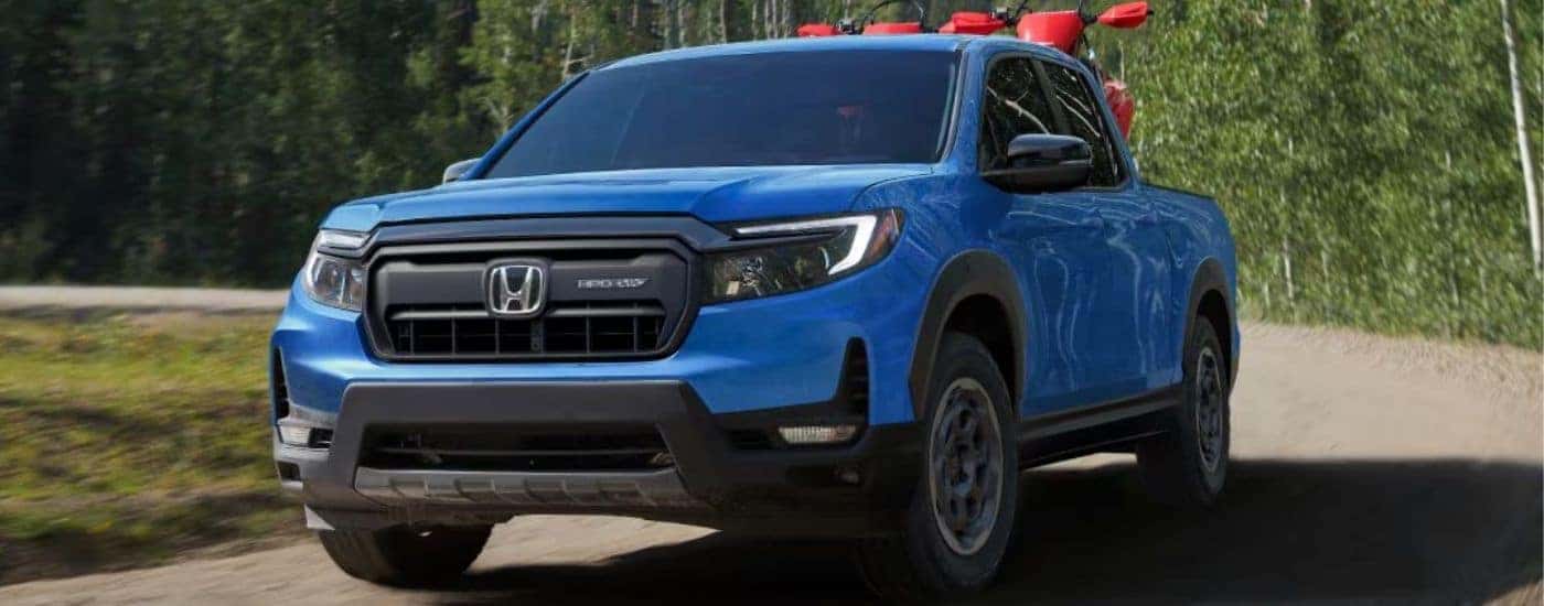 Blue 2025 Honda Ridgeline Trailsport HPO is driving on a dirt road