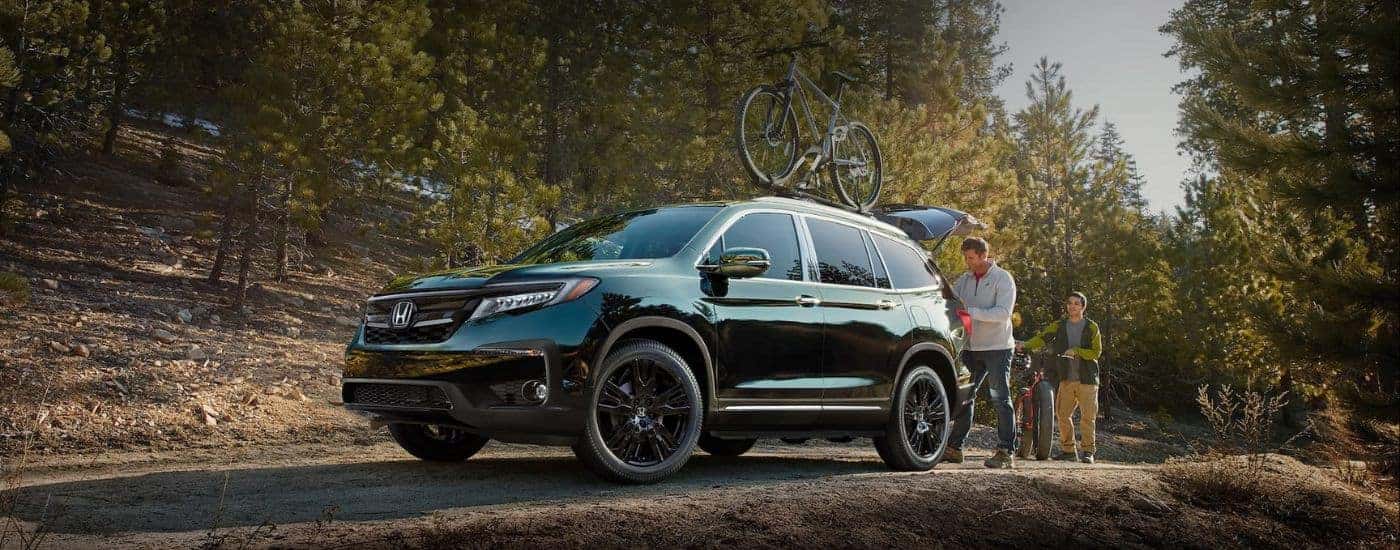 Black 2022 Honda Pilot Elite parked at a hiking trail