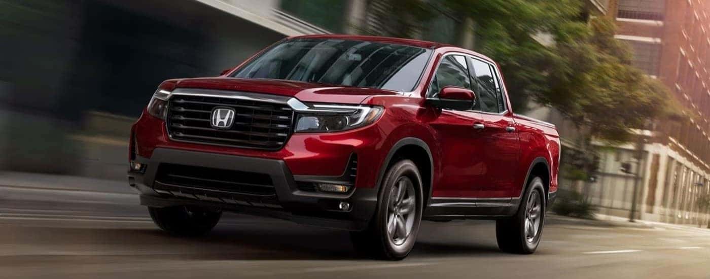 Red 2023 Honda Ridgeline RTL-E driving on a city street