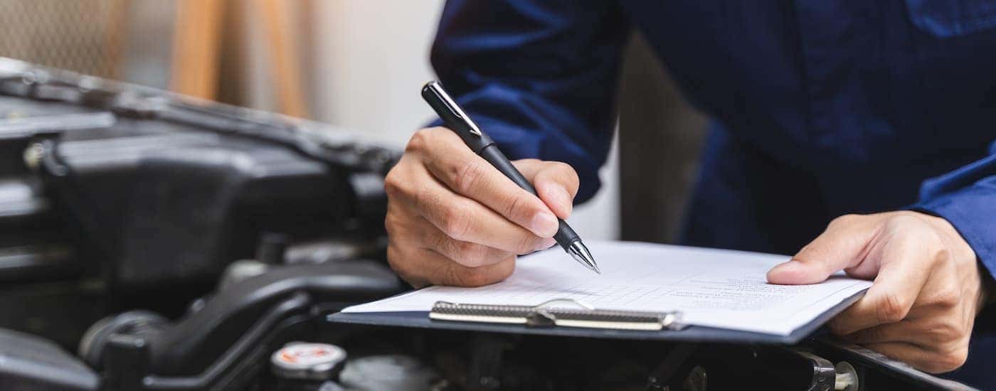 A mechanic going through a checklist for a 200,000-Mile Warranty