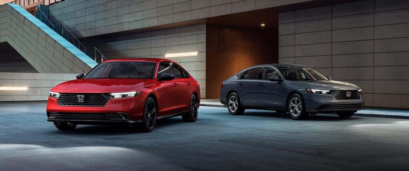A pair of red and gray 2025 Honda Accord from a used car dealer