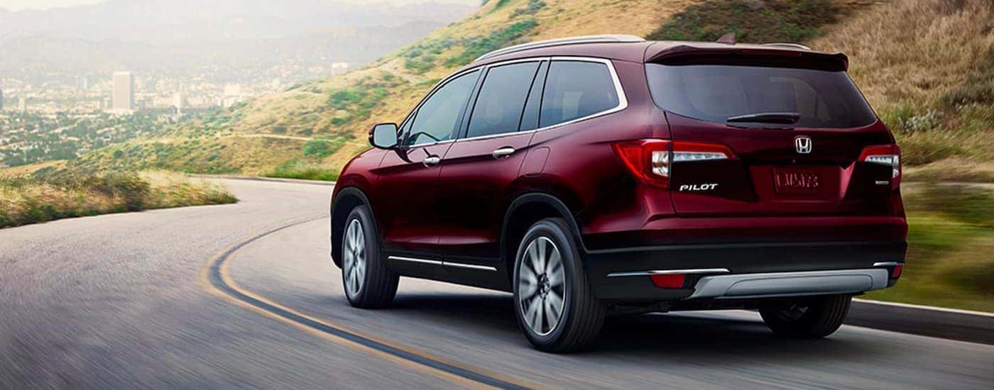 A maroon 2020 Honda Pilot from the rear at an angle.