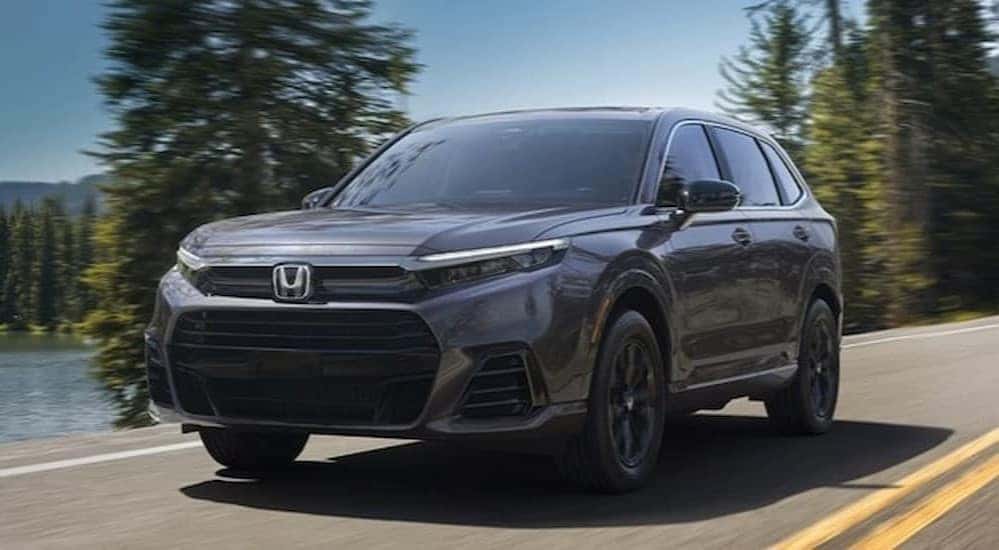 A gray 2026 Honda CR-V driving near a lake.