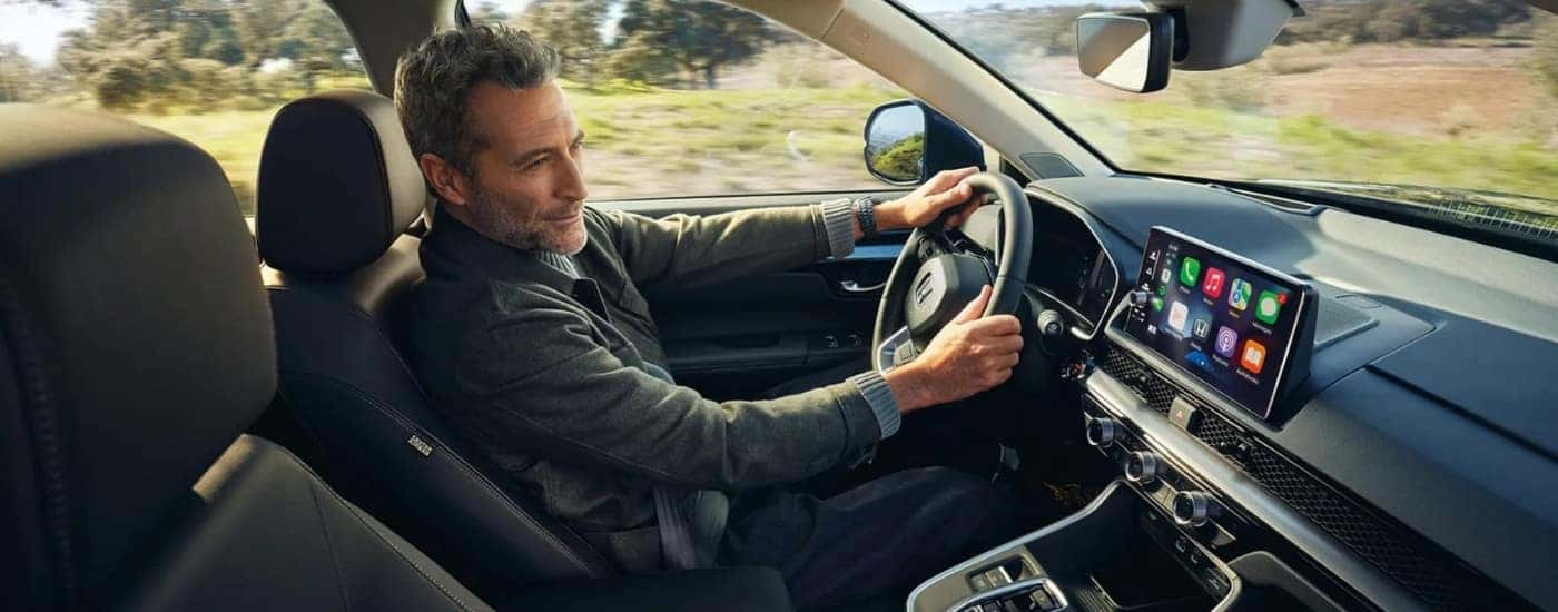 A man using the infotainment display inside a 2025 Honda CR-V Hybrid